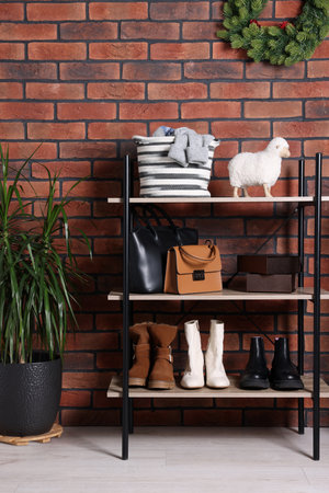 Modern shoe storage bench and potted plant near red brick wall in hallway. Interior designの写真素材