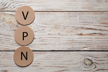 Paper notes with acronym VPN on wooden table, flat lay. Space for textの写真素材