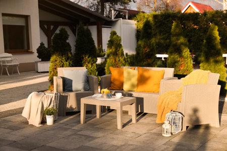 Beautiful rattan garden furniture, soft pillows and different decor elements in backyardの写真素材