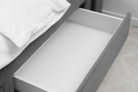 Storage drawer for bedding under modern bed in roomの写真素材
