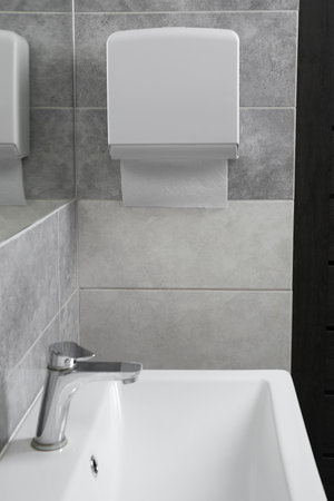 New paper towel dispenser hanging on wall in bathroomの写真素材