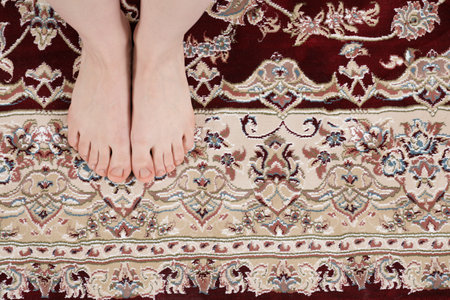 Woman standing on carpet with pattern at home, top viewの写真素材