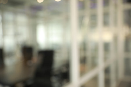 Blurred view of cozy workspaces with tables and chairs in officeの写真素材