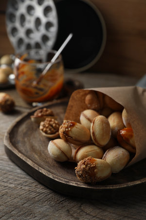 Freshly baked homemade walnut shaped cookies with condensed milk on wooden tableの写真素材