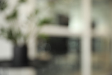 Blurred view of cozy workspaces with tables and chairs in officeの写真素材