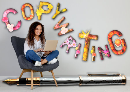 African American woman working on laptop, word Copywriting and big pen on grey background