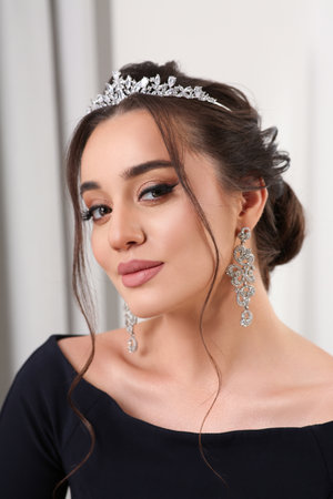 Beautiful young woman wearing luxurious tiara indoorsの写真素材