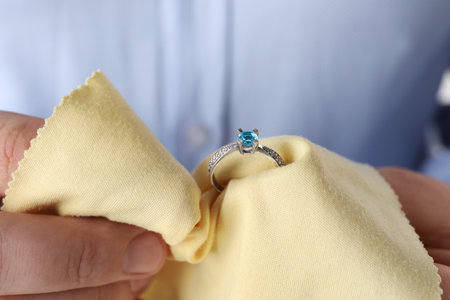Jeweler cleaning topaz ring with microfiber cloth, closeupの写真素材