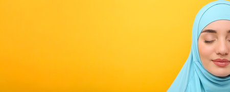 Portrait of Muslim woman in hijab on yellow background, space for text. Banner designの写真素材
