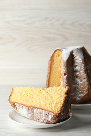Delicious Pandoro cake decorated with powdered sugar on white wooden table. traditional italian pastryの写真素材
