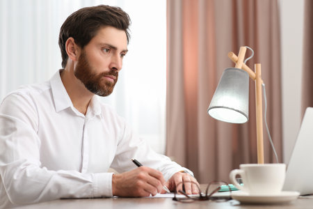 Businessman working with documents at wooden table in officeの写真素材