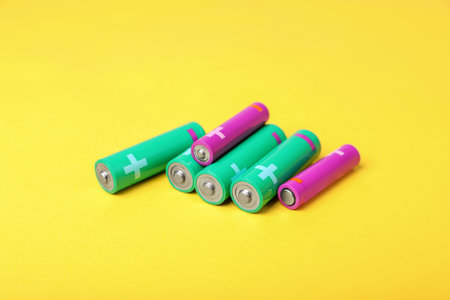 New AA and AAA batteries on yellow backgroundの写真素材
