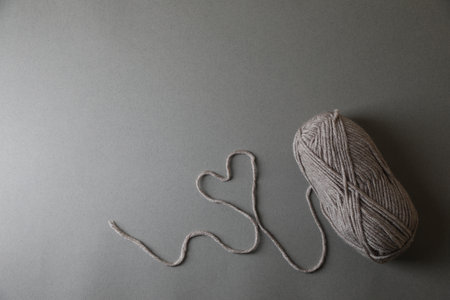 Heart made of soft yarn on light gray background, top view with space for text. Knitting textileの写真素材
