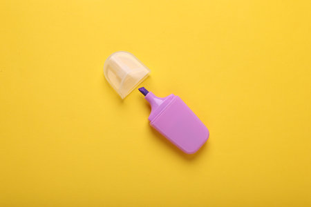 One violet marker with cap on yellow background, top viewの写真素材