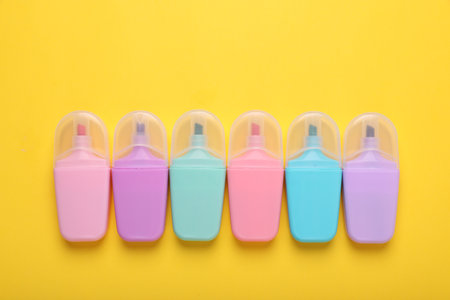 Many colorful markers on yellow background, flat lay. Space for textの写真素材