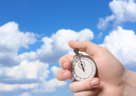 Man holding timer against beautiful sky, closeup. Space for textの写真素材