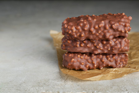 Tasty sweet chocolate bars on light gray table, closeup. Space for text