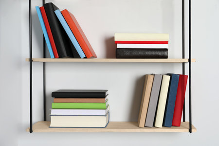Shelves with many hardcover books on white wallの写真素材