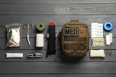 Military first aid kit on wooden table, flat layの写真素材