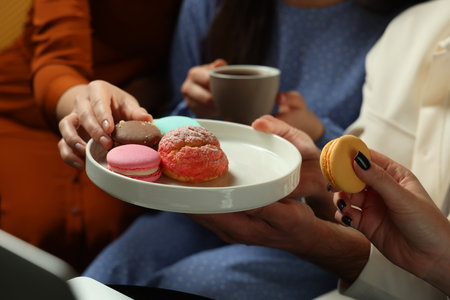 People eating sweet macarons in cafe, closeupの写真素材