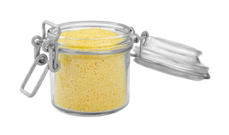 Glass jar of raw couscous isolated on whiteの写真素材