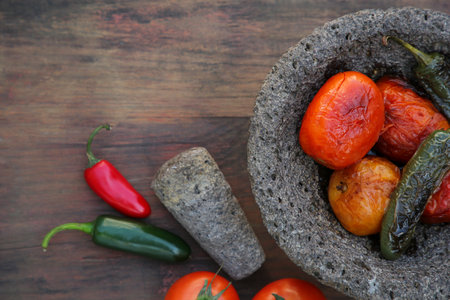 Ingredients for salsa sauce, pestle and mortar on wooden table, flat lay. Space for textの写真素材