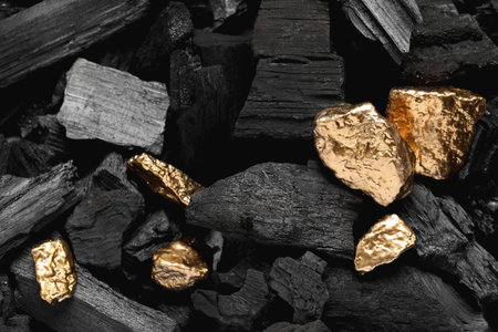 Shiny gold nuggets on coals, closeup viewの写真素材