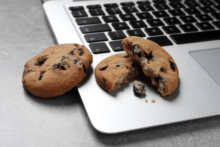 Chocolate chip cookies and laptop on light gray table, closeupの写真素材