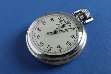 Vintage timer on blue background. Measuring tool