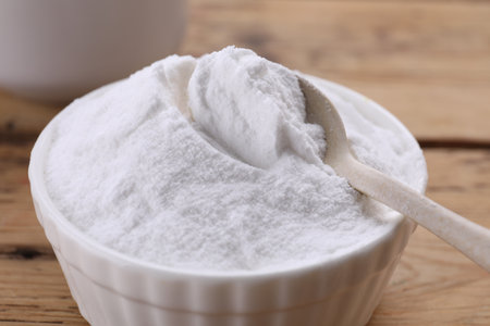 Bowl of fructose powder on wooden table, closeupの写真素材