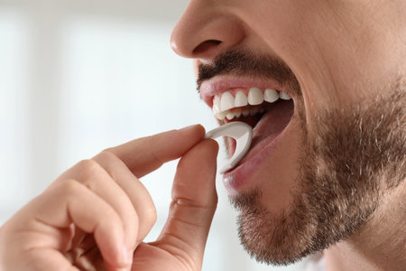 Man putting chewing gum into mouth on blurred background, closeupの写真素材