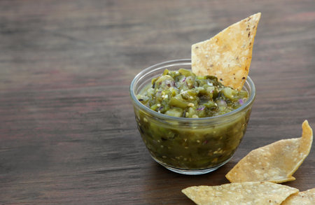 Tasty salsa sauce and tortilla chips on wooden table, closeup. Space for textの写真素材