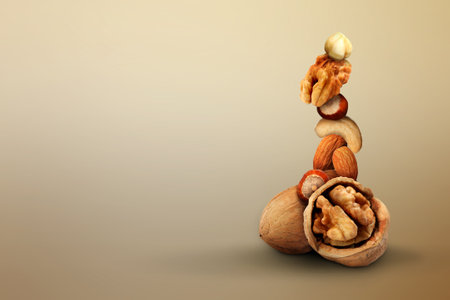 Stacked different nuts on light brown gradient background, space for textの写真素材
