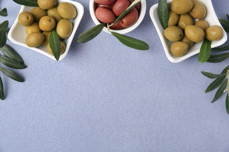 Different fresh olives and leaves on violet background, flat lay. Space for textの写真素材