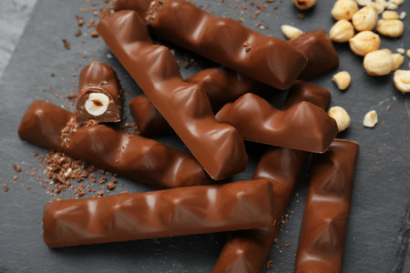 Tasty chocolate bars with nuts on black table, above viewの写真素材