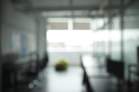 Blurred view of cozy workspaces with tables and chairs in office