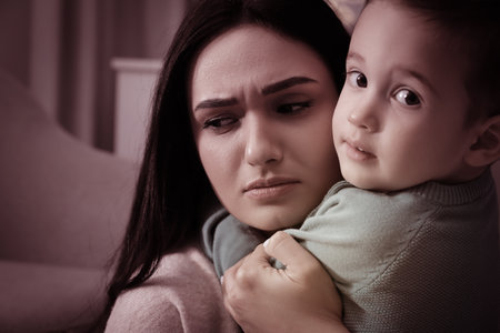 Depressed single mother with child at home, color toned