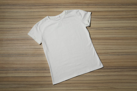 Stylish white T-shirt on wooden table, top viewの写真素材