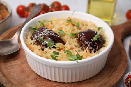 Bowl with sauerkraut and chicken on table, closeup