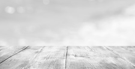 Empty white wooden surface against blurred background, bokeh effect. Banner with space for designの写真素材