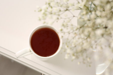 Ceramic mug with tea on white bedside table indoors, top viewの写真素材