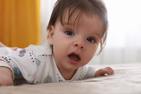 Cute little baby on bed at home