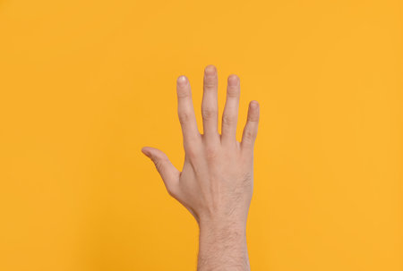 Man giving high five on yellow background, closeup of handの写真素材