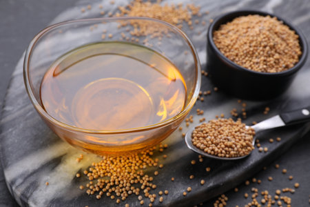Bowl of natural oil and mustard seeds on table, closeup. Space for textの写真素材