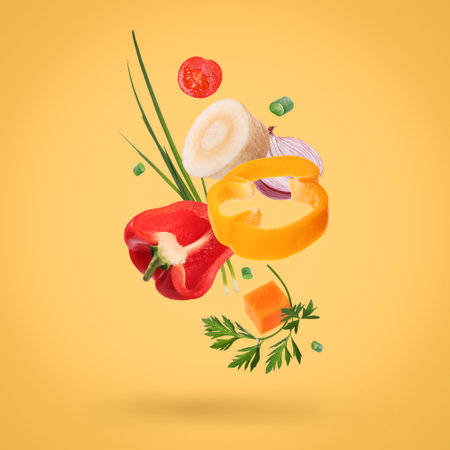 Spice mix for dish. Set of falling fresh vegetables and herbs on golden backgroundの写真素材