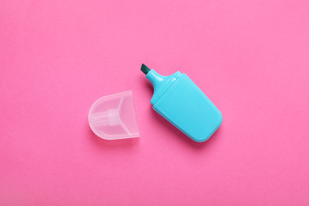 One marker with cap on pink background, top view