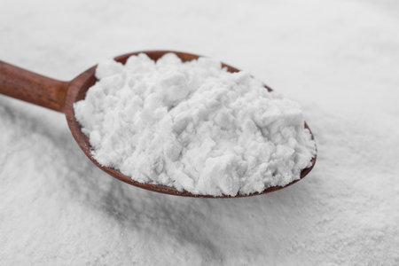Heap of natural starch and wooden spoon, closeupの写真素材