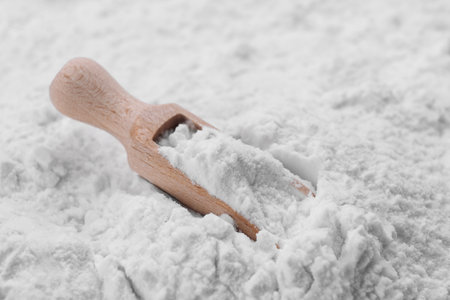 Heap of natural starch and wooden scoop, closeupの写真素材