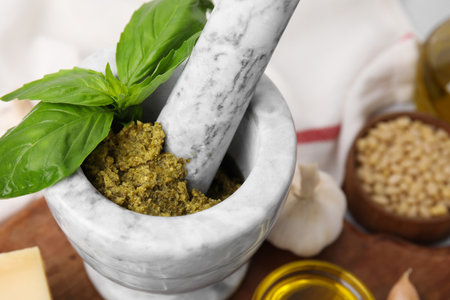 Tasty pesto sauce and fresh basil in mortar, closeupの写真素材