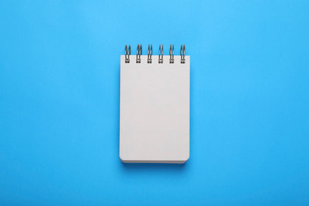 Open notebook on light blue background, top view